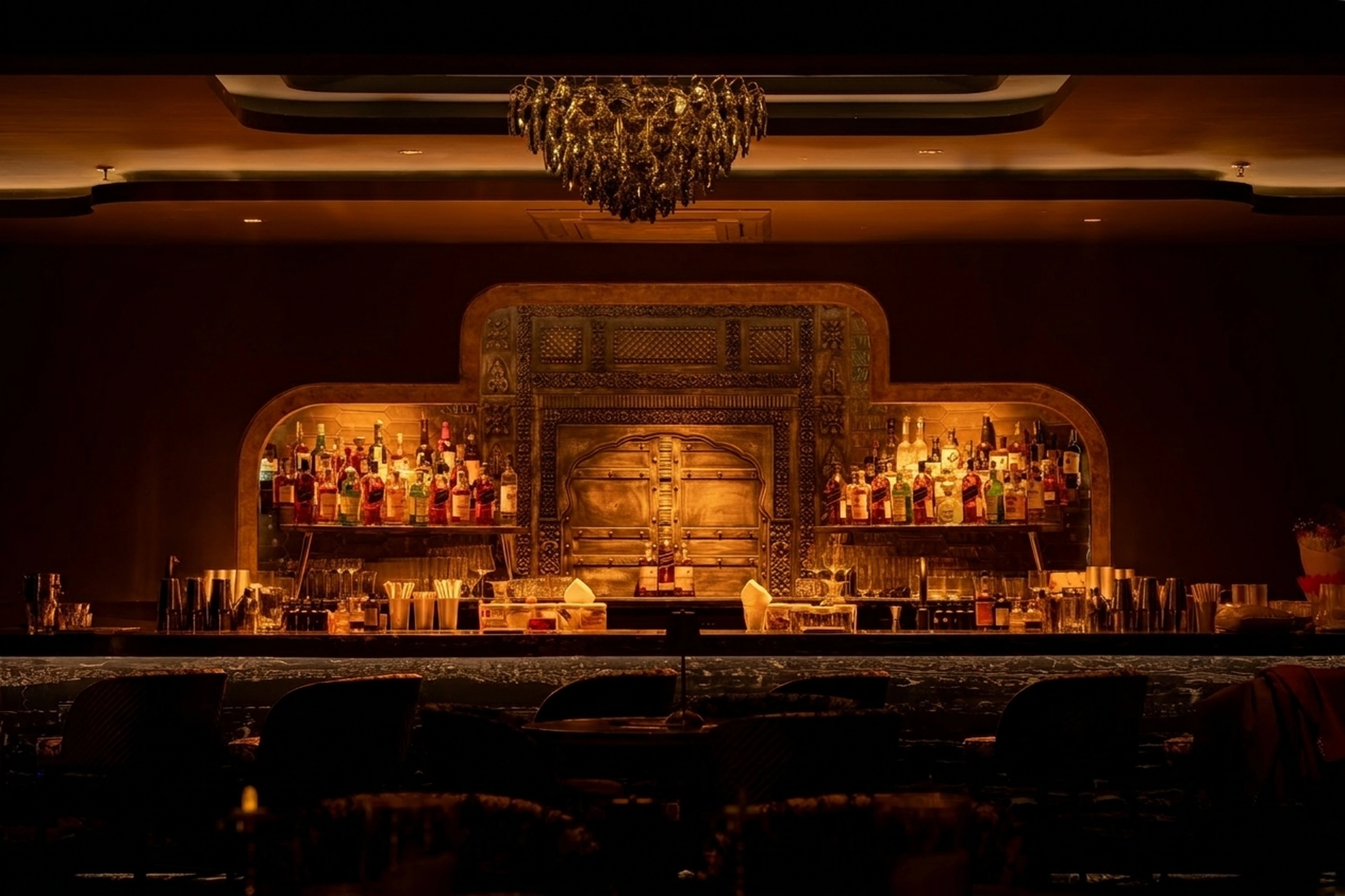 The Dupion cocktail bar, glowing bottles and crystal chandelier